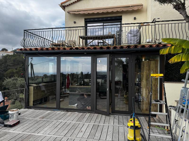 Installation de véranda aluminium haut de gamme alliant design, confort thermique et protection solaire.